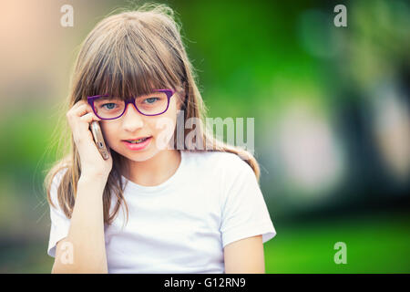 Heureuse jeune fille Pré-ado. Cute little girl dans la ville sur une journée ensoleillée. Portrait jeune fille. La tonalité de l'image. Banque D'Images