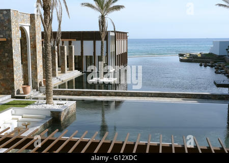 Héraklion, Crète, Grèce - 13 MAI 2014 : Le grand bleu piscine, bâtiment moderne avec des colonnes, des palmiers et de la plage dans l'hôtel Banque D'Images
