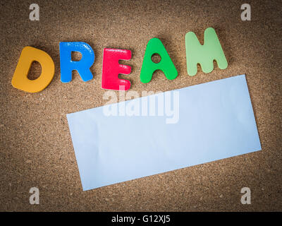 Mot en bois coloré Dream avec la feuille de papier blanc sur le panneau de liège Banque D'Images