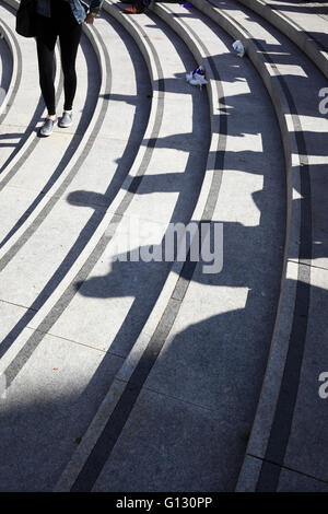 Ombre de personnes sur les mesures concrètes en dehors du Forum, à Norwich, Norfolk, Royaume-Uni. Banque D'Images