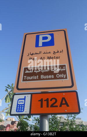 Inscription en anglais et arabe indiquant payer au compteur, payer par téléphone et bus touristiques uniquement, Deira, Dubaï, Émirats Arabes Unis Banque D'Images