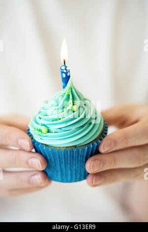 Hands holding birthday cupcake Banque D'Images