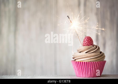 Décorées avec Cupcake buttercream chocolat et un sparkler Banque D'Images