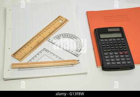 Le concept de l'apprentissage présenté avec une calculatrice & crayons sur un fond de papier graphique Banque D'Images