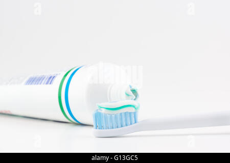 Tube de dentifrice avec une petite quantité de dentifrice sur une brosse à dents Banque D'Images