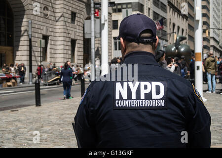La lutte contre le terrorisme de NYPD Officier de service, Bull charge Sculpture à Bowling Green Park, NYC Banque D'Images
