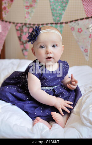 Adorable petite fille assise sur le sol portrait charmant studio shot Banque D'Images