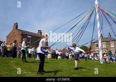 Les enfants préparent les rubans avant de danser autour du mât de mai à Aldborough jour festival Banque D'Images