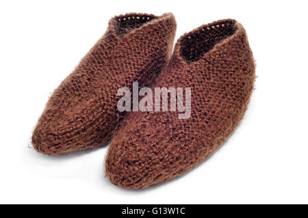 Une paire de chaussons tricot brun sur un fond blanc Banque D'Images