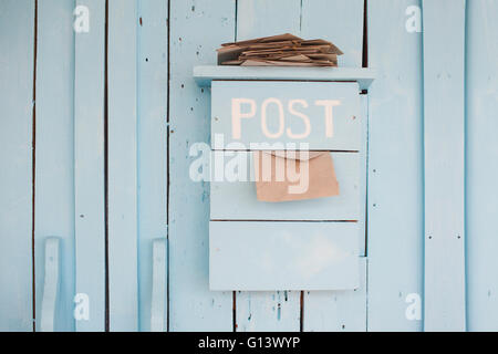 Boîte aux lettres avec des lettres dans un style vintage sur fond bleu en bois Banque D'Images