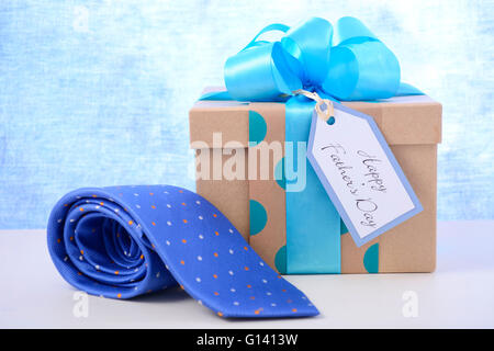 Cadeau Fête des Pères heureux et cravate sur table en bois blanc et fond bleu pâle. Banque D'Images