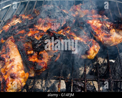 Chargilled et brûlé les morceaux de poulet sur un barbecue Banque D'Images