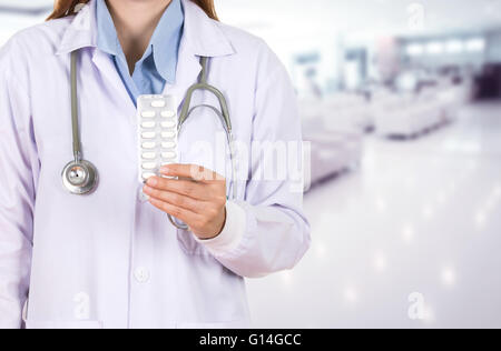 Female doctor holding avec des pilules dans l'arrière-plan de l'hôpital Banque D'Images