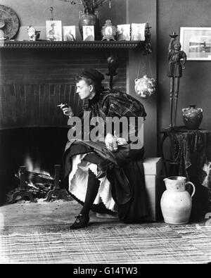 Johnston, assis devant le foyer, orienté vers la gauche, tenant cigarette dans une main et une bière stein dans l'autre, dans son studio de Washington, D.C., 1896. Frances 'Fannie' Benjamin Johnston (15 janvier 1864 - 16 mai 1952) a été un des premiers American f Banque D'Images