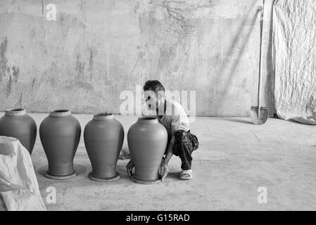 Fazl Abol, Potter's assistant, avec des pots d'argile faites par Iradj Naderi dans son atelier de Lalejin, Hamadan, Province de l'Iran. Banque D'Images