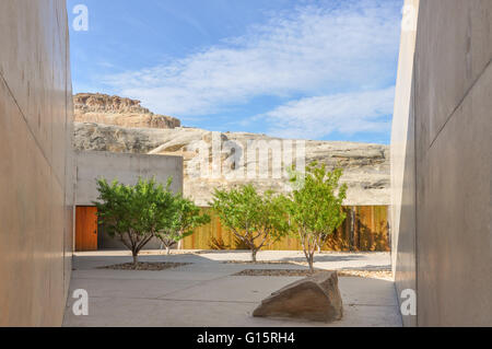 Murs en béton entourant une terrasse avec arbres verts et formations rocheuses dans un complexe de l'Utah, Amangiri Banque D'Images