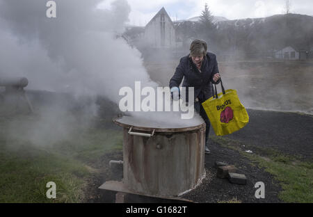 Dans le village de Hveragerdi près de Reykjavik est une femme à l'aide d'une source géothermique. Pâte à pain emballé dans un carton de lait vide est étuvé en 12 heures pour le pain. 20 avr, 2016. © Hans Van Rhoon/ZUMA/Alamy Fil Live News Banque D'Images