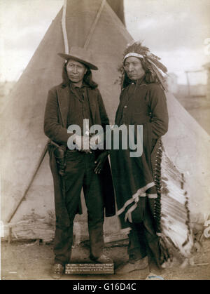 Deux chefs Oglala, American Horse (porter des vêtements occidentaux et gun-en-étui) et Red Cloud (portant la coiffure), serrer la main en face de tipi, probablement sur ou près de la réserve de Pine Ridge. Photographié par John C.H. Grabill, 1891. American Horse (1840 - Banque D'Images