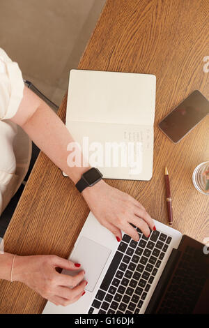 Vue de dessus d'une femme assise à son bureau et travaillant sur un ordinateur portable. femme d'affaires travaillant à domicile. Banque D'Images