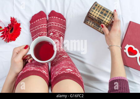 Femme ayant une tasse de thé au lit, point de vue Banque D'Images