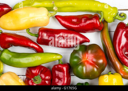 Technique mixte rouge, jaune et vert poivrons sur table en bois blanc Banque D'Images