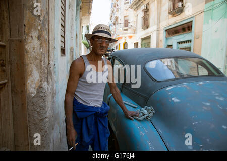Un homme portant un chapeau de paille se distingue par sa vieille voiture américaine des années 50 il est affectueusement la restauration dans la Habana Vieja Cuba Banque D'Images