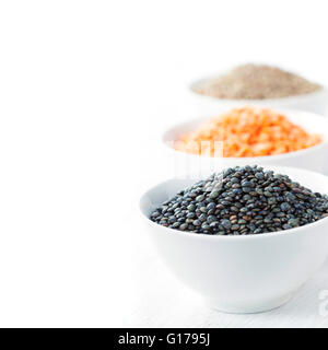 Assortiment de bols de lentilles sèches avec lentilles rouges, lentilles beluga noir et blanc sur les lentilles de montagne Banque D'Images