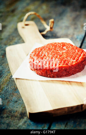 La viande de boeuf haché cru Burger steak frite sur planches de bois vintage Banque D'Images