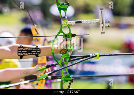 Les gens sont le tir avec arcs recurve lors d'une compétition de tir à l'ARC. Les mains et s'incline seulement. Green bow. Banque D'Images