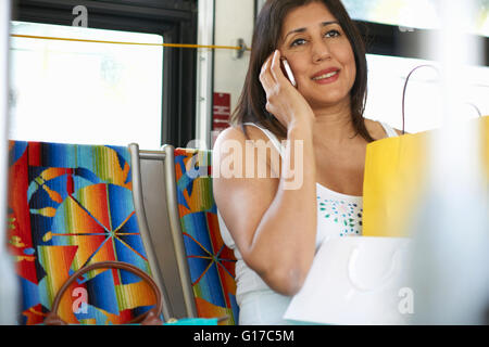 Femme assise sur le bus chatting on smartphone, Los Angeles, Californie, USA Banque D'Images