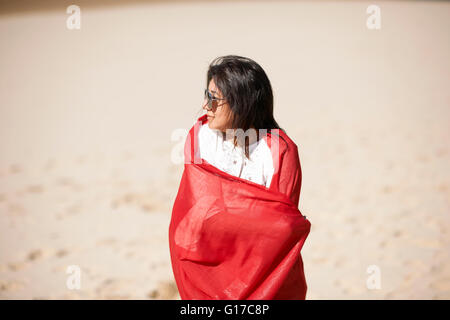 Femme au Châle rouge bénéficiant beach Banque D'Images