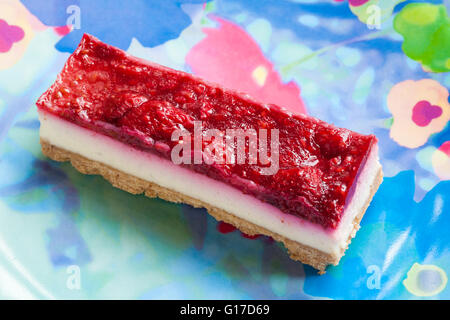 M&S Esprit de l'été et vanille framboise série de coupes de gâteau au fromage sur la plaque de couleur Banque D'Images