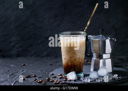 Verre de glace Café avec lait et crème, servi avec des grains de café, des cubes de glace et cafetière sur ardoise sur le texte en noir Banque D'Images