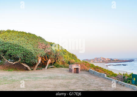 Les derniers rayons du soleil illumine les plantes à un camping en Buffelskop avec la ville de Buffels Bay à l'arrière Banque D'Images