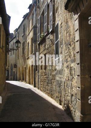 Ruelle étroite éclairée par le soleil dans le centre historique de Sarlat, Dordogne, France Banque D'Images