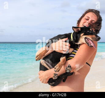 Femme à Shoal Bay holding dog elle a sauvé à Anguilla Banque D'Images