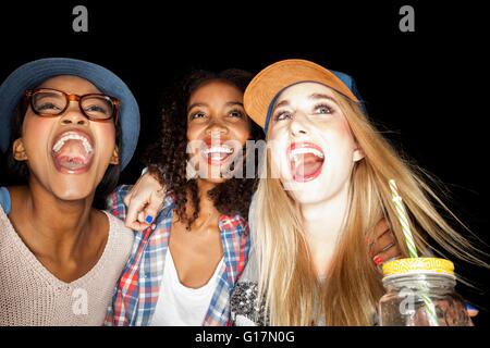 Les jeunes femmes entassés jusqu'à la bouche ouverte, smiling Banque D'Images