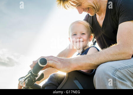 Père et fille de bébé riding bike ensemble Banque D'Images