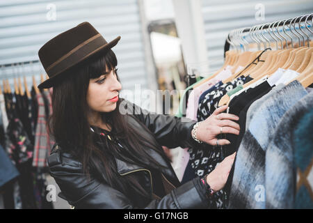 Jeune femme vêtements navigation at market Banque D'Images