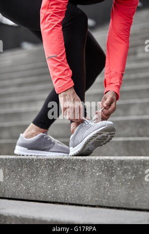 Cropped shot of woman de la formation sur l'escalier de la ville, les lacets formateur Banque D'Images