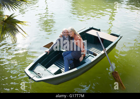 Couple en bateau à rames sur le lac hugging her smiling Banque D'Images