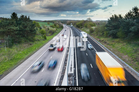 Voitures en mouvement sur l'autoroute à deux fois deux voies entre les champs de printemps vert Banque D'Images