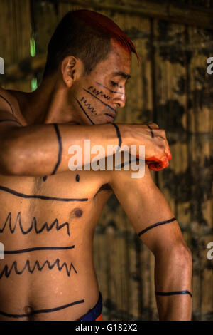 SANTO DOMINGO, l'Équateur, le 26 janvier 2015 : Indian man (Los Colorados Tsáchila) tribu dans les peintures vêtements usine de jus de cheveux Banque D'Images