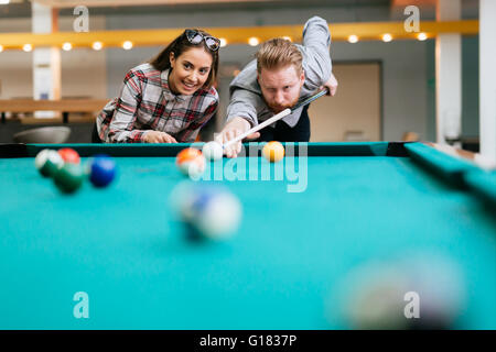 Beau couple heureux en jouant au billard Banque D'Images