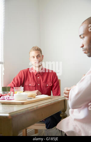 Couple assis à table à manger en faisant valoir Banque D'Images