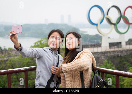 Deux jeunes filles en se faisant passer pour un téléphone intelligent avec un selfies à Nanjing en Chine Banque D'Images