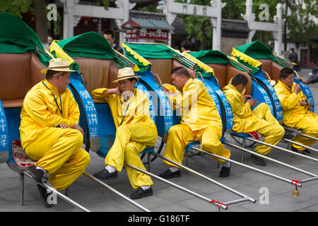 Les conducteurs de rickshaw jaune habillé en appui de prendre une pause de détente à partir de leur travail dans la ville de Nanjing en Chine Banque D'Images