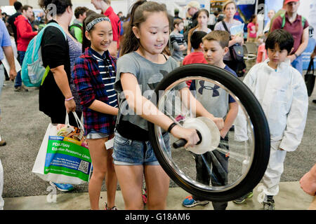 La physique d'apprentissage jeune fille de gyroscope avec une roue de vélo à une expo-sciences - USA Banque D'Images