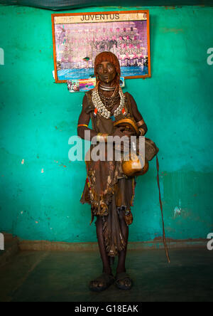 Tribu Hamer femme debout en face d'une vieille affiche de la Juventus, vallée de l'Omo, Ethiopie, Turmi Banque D'Images