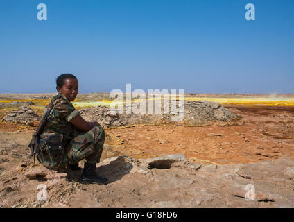 Femme Soldat éthiopien en face de paysages volcaniques colorés dans la région Afar, dépression Danakil, Dallol, Ethiopie Banque D'Images